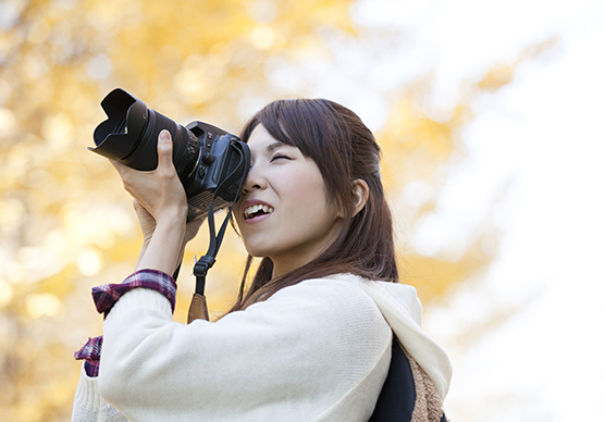 デジタルカメラで風景を撮影している女性