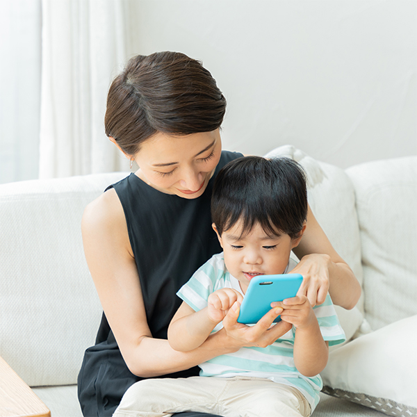 スマホでフォトグッズを作成する親子
